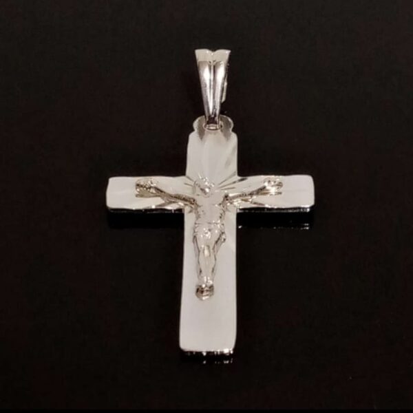 Dije de cruz de plata con Jesús, una joya con un profundo significado religioso.
