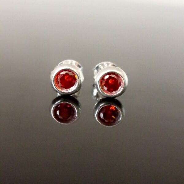 Energía y Elegancia: Aretes que Transforman tu Actitud Diaria Accesorio premium antiestrés con granate rojo y plata de alta calidad